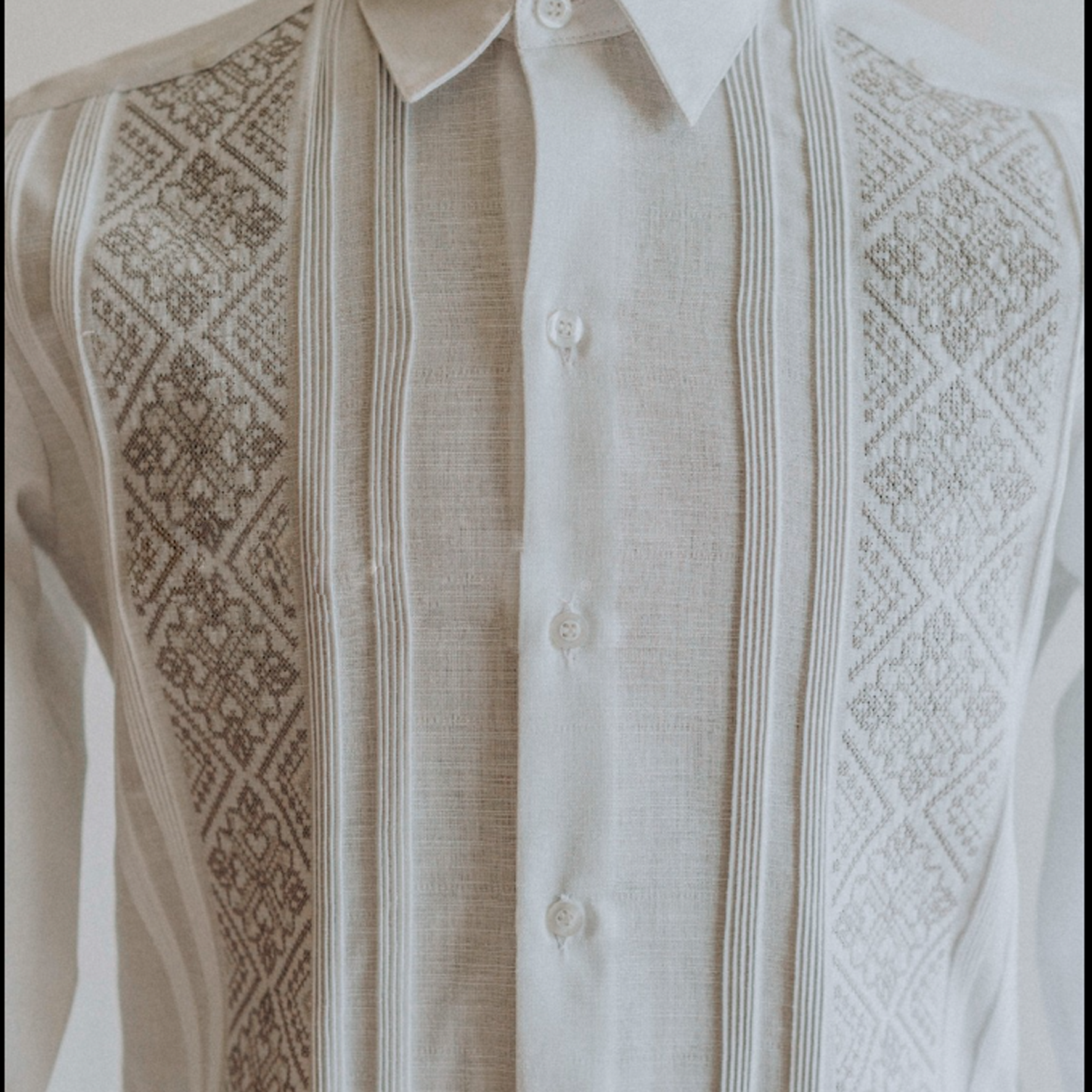 Détail broderie grise sur chemise guayabera blanche élégante