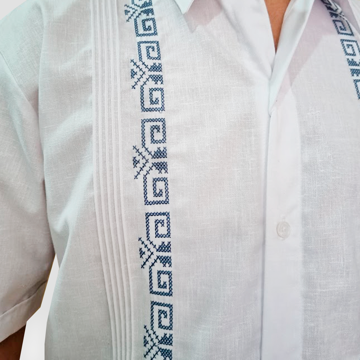 Détail de la broderie bleue sur guayabera blanche en lin