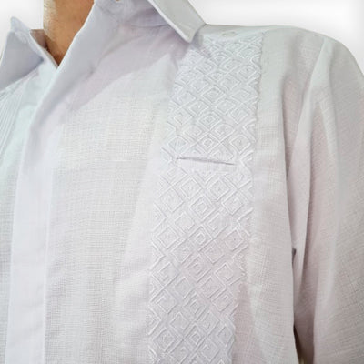 Détail des broderies et plis sur une guayabera de mariage artisanale