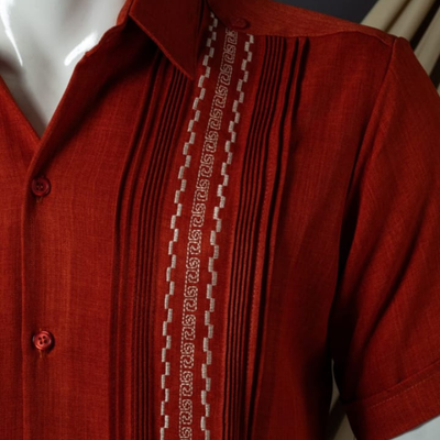 Détail des broderies fines sur guayabera rouge Casa Habana
