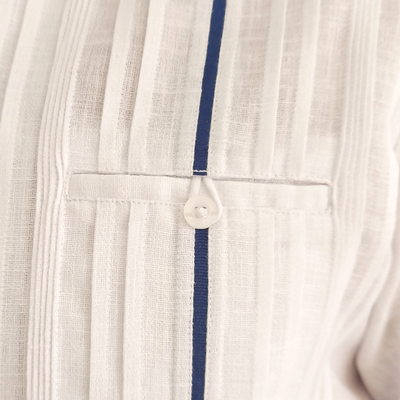 Détail du liseré bleu sur une guayabera blanche élégante en coton