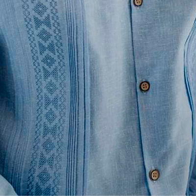 Détail du motif brodé bleu sur guayabera élégante homme
