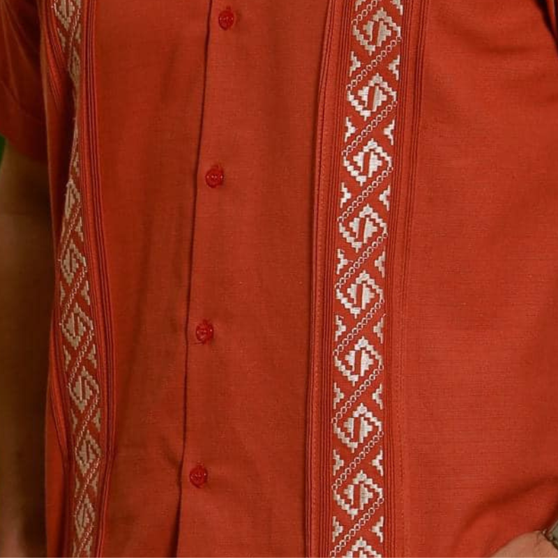 Homme élégant portant une guayabera terracotta brodée – style tropical chic