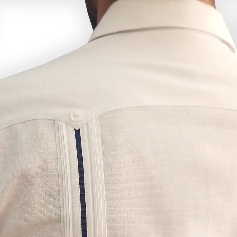 Marié portant une guayabera blanche à liseré bleu pour mariage en bord de mer